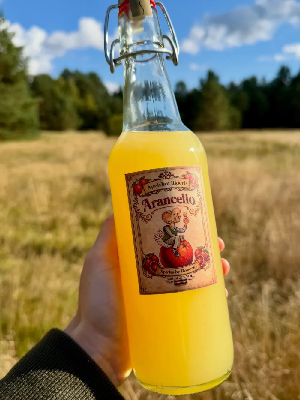 Arancello pudele saulainā pļavā