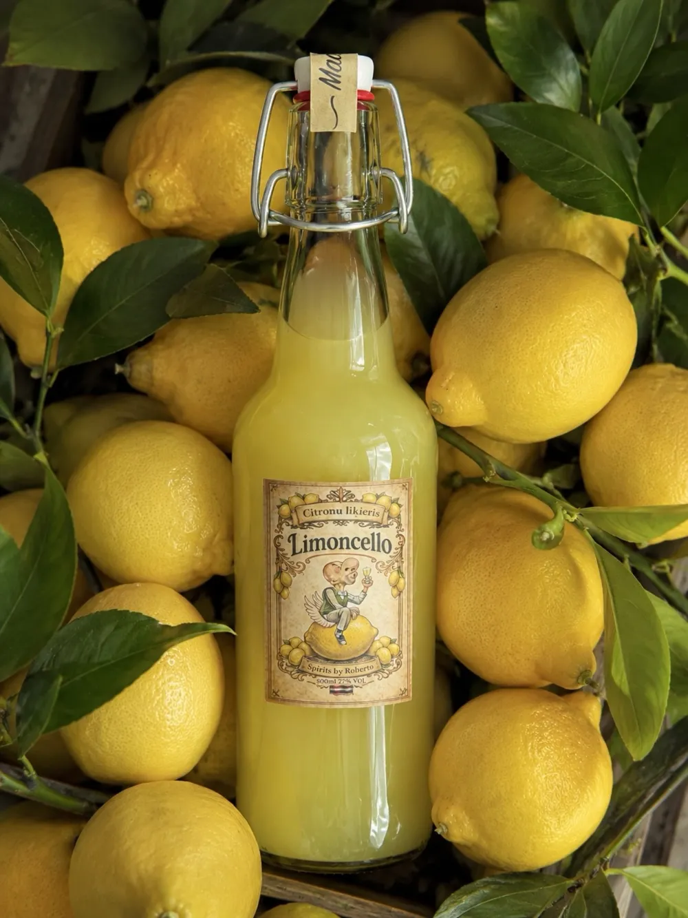 Limoncello pudele starp citroniem un lapām