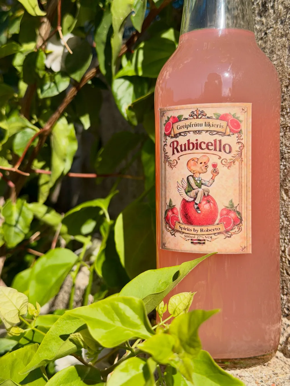 Rubicello pudele starp zaļām lapām